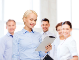 Image showing smiling woman looking at tablet pc computer