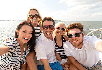 Image showing smiling friends sitting on yacht deck