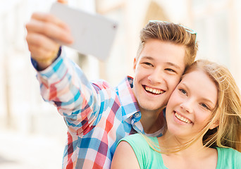 Image showing smiling couple with smartphone in city