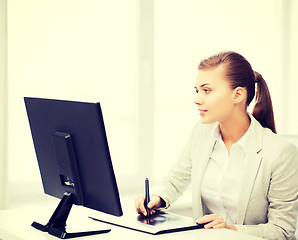 Image showing businesswoman with drawing tablet in office