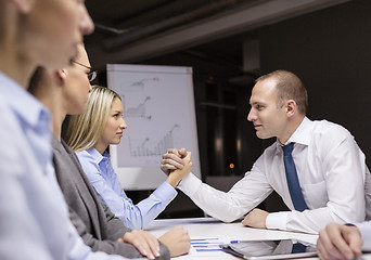 Image showing businesswoman and businessman arm wrestling