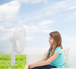 Image showing smiling little girl with big fan at home