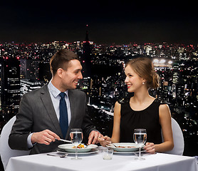 Image showing smiling couple eating main course at restaurant