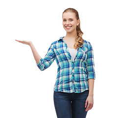 Image showing smiling young woman holding something on hand