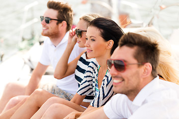 Image showing smiling friends sitting on yacht deck