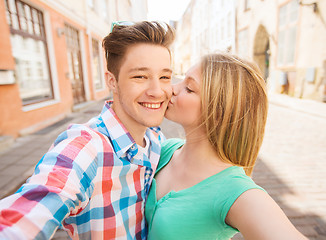 Image showing smiling couple with smartphone in city