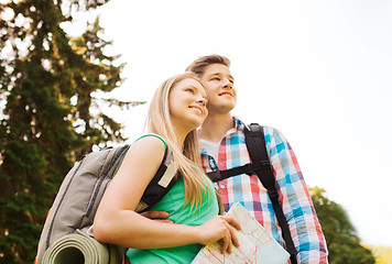 Image showing smiling couple with map and backpack in nature