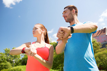 Image showing smiling people with heart rate watches outdoors