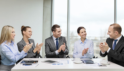 Image showing business team with laptop clapping hands