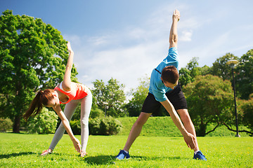 Image showing smiling couple stretching outdoors