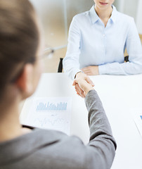 Image showing two calm businesswoman shaking hands in office