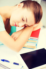 Image showing tired student sleeping on stock of books