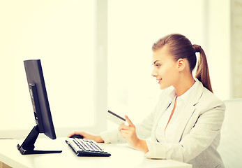 Image showing businesswoman with computer using credit card