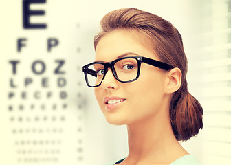 Image showing woman in eyeglasses with eye chart