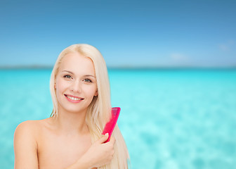 Image showing smiling woman with hair brush