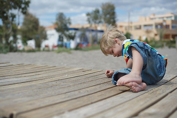 Image showing Boy playing on a wooden walkway on the beach