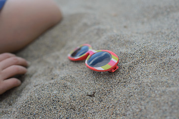 Image showing Striped sunglasses in the sand