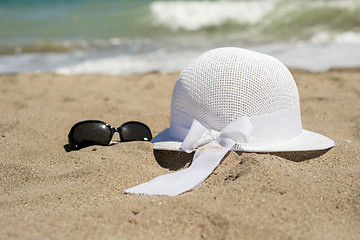 Image showing Wicker white hat and sunglasses on the beach