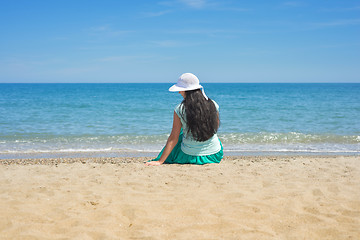 Image showing Brunette female sitting alone on the beach