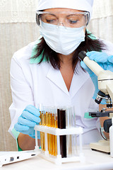 Image showing scientist in laboratory analyzing yellow liquid in test tube