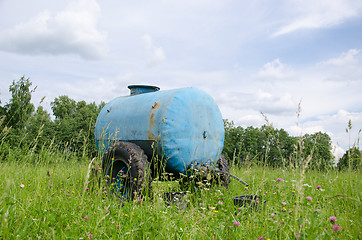 Image showing Blue water cistern drink for animal between grass 