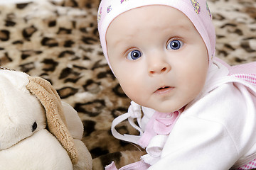 Image showing surprised baby in a cap with a soft toy