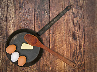 Image showing vintage set for frying eggs over wooden table