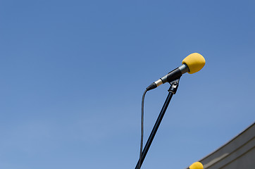 Image showing yellow microphone on blue sky background 