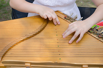 Image showing ancient stringed baltic psaltery and girls hands 