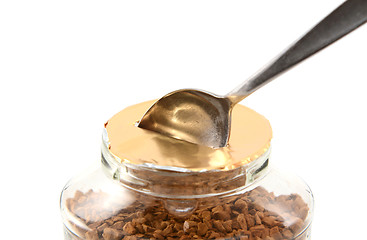 Image showing Teaspoon breaking the foil seal on a jar of coffee