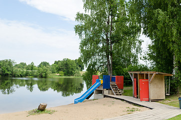 Image showing changing cabin and water slide at beach shore 