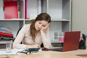 Image showing Girl sleeping on a workplace at office