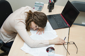 Image showing Tired woman asleep on a workplace at office