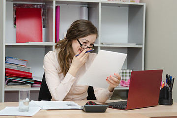 Image showing Girl laughs while reading a document in the workplace