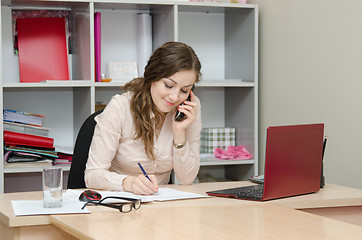Image showing Business woman calling by phone and does records