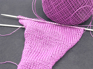 Image showing Pink colored knitting on a  black background