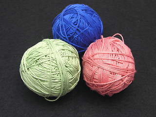 Image showing Three balls of wool  on a black background