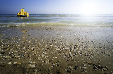 Image showing Yellow lifeboat on the beach.