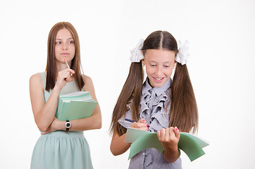 Image showing The teacher looks at the student with a notebook