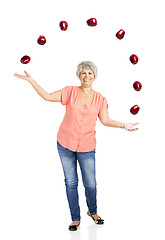 Image showing Old woman throwing apples