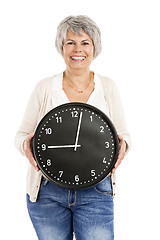 Image showing Elderly woman holding a clock