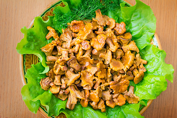 Image showing Fried mushrooms of chanterelle on a dish together with lettuce l