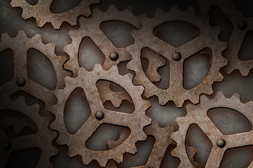 Image showing Distressed interlocking gears lit diagonally