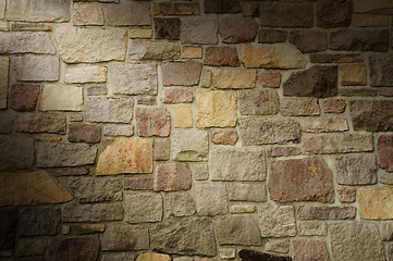 Image showing Masonry Wall of Multicolored Stone Lit Diagonally