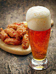 Image showing glass of fresh beer and fried chicken wings