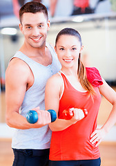 Image showing two smiling people working out with dumbbells