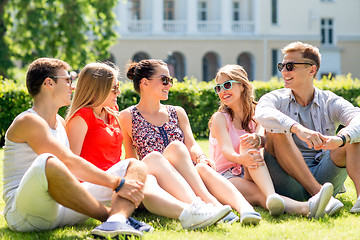 Image showing group of smiling friends outdoors sitting on grass