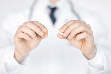 Image showing man breaking the cigarette with hands