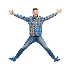 Image showing smiling young man jumping in air