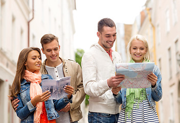 Image showing group of smiling friends with city guide and map